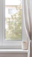 Serene home interior with a bright window, sheer curtain, and minimalist plant pot on a clean windowsill, inviting natural light and calm. photo