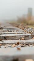 Misty Autumn Railway Concrete Sleepers and Fallen Leaves on a Fog-Enveloped Track, Evoking a Sense of Quiet Journey and Rustic Beauty. photo