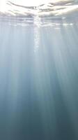 Captivating Underwater Light Rays in Deep Blue Ocean. Tranquil Water Surface, Shimmering Bubbles. Serene Aquatic Background. photo