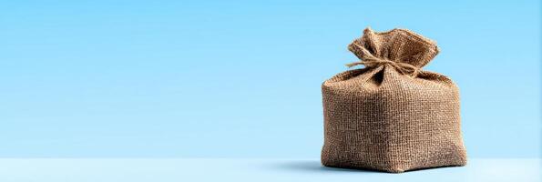 Eco-friendly Burlap Packaging Sits Against a Clear Sky-Blue Background photo