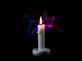 A white candle with blue and red smoke coming out of it photo