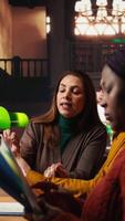 Vertical African american woman asking people for silence in a public library, being disturbed by their collective studying with a lot of noise. Mature colleagues learning with disrespect. Camera A. video