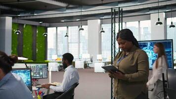 contento femmina ingegnere nel ufficio automatizzare ripetitivo compiti utilizzando ai script. gioviale africano americano sviluppatore utilizzando artificiale intelligenza per velocità su caratteristica implementazione, telecamera un' video