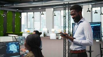 Lycklig programmerare design och utvecklande programvara applikationer, optimerande koda för prestanda och skalbarhet. glad den expert- i kontor använder sig av läsplatta till lösa flaskhalsar, kamera en video