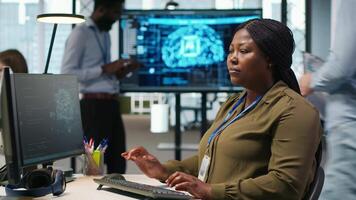 kvinna tekniker skrivning koda på pc, utvecklande neuralt nät apis. systemet administratör använder sig av dator till felsöka programvara fel med artificiell intelligens teknologi, kamera en video