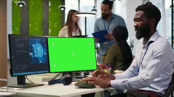 Software developer using AI on green screen computer to optimize performance and forecast issues. Man in office training machine learning models using mockup PC, camera A video