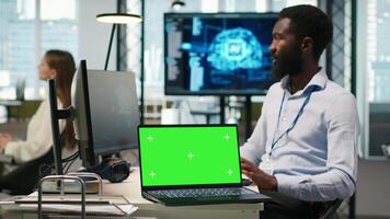 comece escritório programador usando verde tela computador portátil, em desenvolvimento artificial inteligência modelos para o negócio análise. isto especialista usando brincar caderno, corrida simulações para ai previsão, Câmera uma video