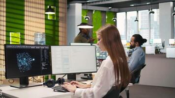 Startup office IT professional using AI LLM chatbot, optimizing systems performance. Computer scientist uses artificial intelligence assistant to automate workflows, camera A video