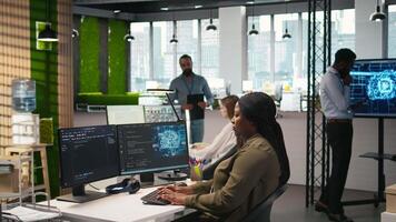 Computer Wissenschaftler im Anfang Büro Überprüfung ai System Metriken, Überwachung Performance Dashboards. afrikanisch amerikanisch Frau Tuning neural Netzwerke mit Werkzeuge auf PC, Kamera ein video