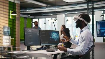 programmerare bär vr headsetet på kontor skrivbord utvecklande program använder sig av ai automatisering. börja arbetstagare använder sig av virtuell verklighet teknologi, felsökning tillämpningar med artificiell intelligens, kamera en video