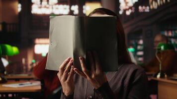 Mature person enjoying lecture at a public library and reading many books, feeling relaxed and increasing his knowledge during retirement period. Happy pensioner with spectacles. Camera A. video