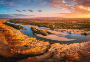 Aerial View of a Meandering River at Sunset in a Desert Canyon photo