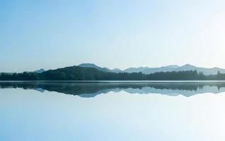 Serene Lake Reflection with Misty Mountains photo