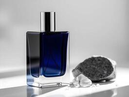 A bottle of perfume sitting on a table next to a rock photo