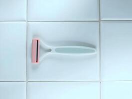 A razor is sitting on a tile floor photo