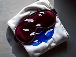 A sleeping mask and a towel with a red and blue eye mask photo