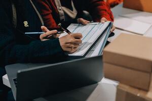 Two people working on a laptop with boxes around them photo