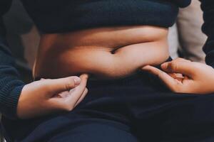 A person is holding their stomach with their hands photo