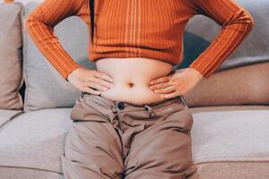 A woman sitting on a couch with her stomach on the floor photo