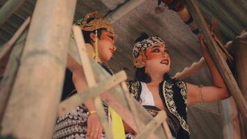 brincalhão javanese casal interagindo dentro uma rústico bambu cabana video