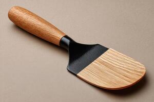 A wooden spatula with a black handle photo