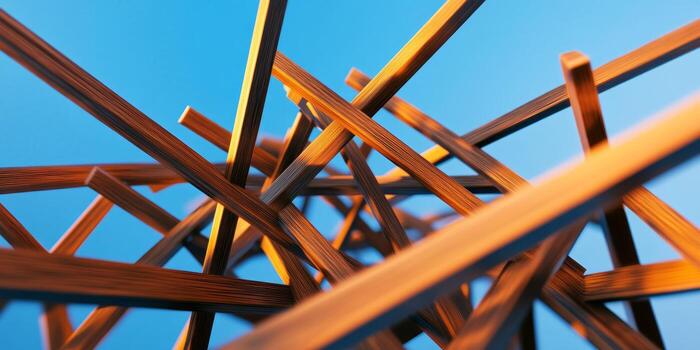 Wooden sticks intersecting under a bright blue sky creating an abstract natural arrangement photo
