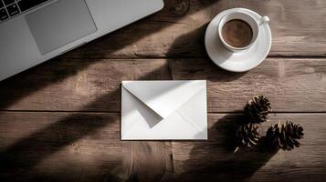 White envelope, laptop, coffee and pine cones on wooden table photo