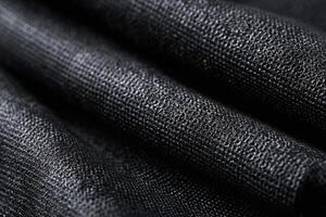 Deep black Kevlar weave fabric displaying subtle texture and intricate patterns in natural light photo
