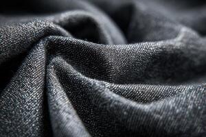 Charcoal denim fabric showcasing intricate texture and deep color details in a close up shot photo