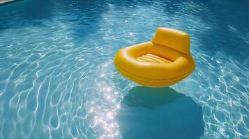 Yellow inflatable chair floating on swimming pool water surface photo