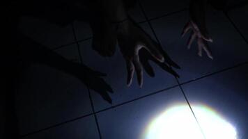 Hands Reaching Towards Light on Tiled Floor video