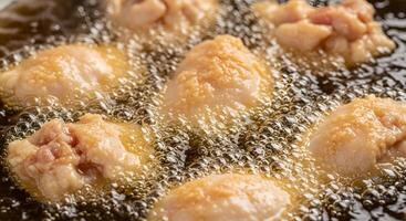 Chicken wings in oil frying in a pan photo