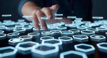 A person touching a hexagonal object on a table photo