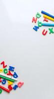 Colorful alphabet letters and pencils on a white surface photo