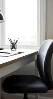 A black chair is sitting in front of a desk photo