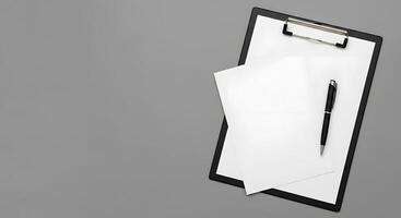 A clipboard with a pen and paper on top photo