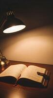 An open book and a lamp on a desk photo