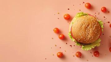 Hamburger with tomatoes and sesame seeds on a pink background photo