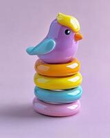 A colorful bird toy sits on top of a stack of rings photo