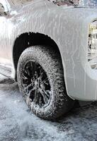 Washing Foam On A Front Wheel Of Vehicle photo