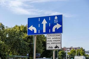 Blue urban traffic direction sign details multi-lane flow for cars, including a dedicated BUS DOP lane, managing authorized transportation and public services photo