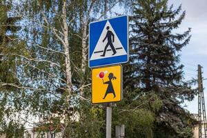 Prominent road signs displaying pedestrian crossing and child safety symbols, promoting crucial awareness and caution for drivers in an urban environment photo