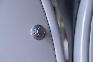 Contemporary silver button featuring a clothes hanger symbol, signifying smart laundry functionality for efficient garment care in modern home appliances photo