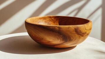 Natural wood bowl on a table. Sunny light, dappled shadows, beautiful texture. photo
