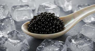 Close-up of fresh black caviar on a spoon, surrounded by ice cubes. photo