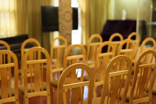 The area has neatly arranged empty chairs ready for an event in a simple, spacious hall photo