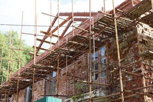 A Construction Site with Scaffolding on a Brick Building shows activity and development photo