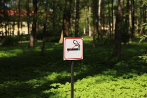 A prominent No Smoking Sign amidst the lush greenery is vital for public awareness and health photo