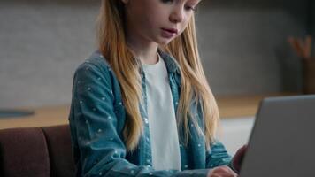Caucasian family concept little schoolgirl with laptop at home kitchen child girl school kid daughter with computer e-learning play game studying distant education using cyberspace pc online internet video
