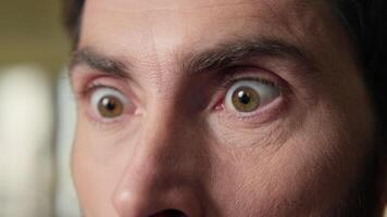 Close up shocked business man big eyes staring mobile phone screen shock wonder amazed stunned reaction message news in office afraid excited businessman male face emotion astonishment unbelievable video